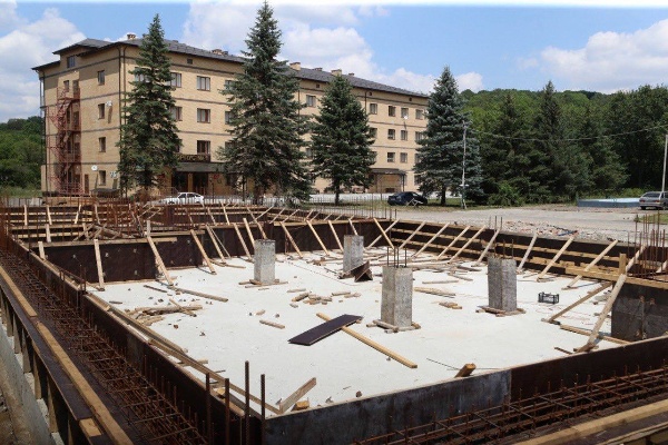 В селе Сурхахи Назрановского района полным ходом идет реконструкция Дома ветеранов. 

Старое здание, построенное в 1992 году, будет полностью демонтировано, а на его месте появится современный трехэтажный корпус площадью 1590 кв. м. 

Новый корпус сможет принять 50 постояльцев.

Сейчас уже завершены земляные работы, залита фундаментная плита и ведется возведение железобетонного каркаса. 

Чтобы ускорить строительство, планируется увеличить число рабочих бригад и перейти на двухсменный режим работы. 

Стоимость проекта превышает 263 миллиона рублей.  Завершить строительство планируется в июне следующего года.