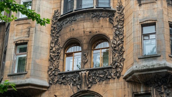 Монументальный дом на Лиговском проспекте, 44, в Санкт-Петербурге, построенный в 1910-1912 годах по заказу гражданского инженера Александра Николаевича Перцова, по проекту арх. С.П.Галензовского и И.А.Претро является обьектом культурного наследия регионального значения.

Одна из самых интересных историй, связанных с жильцами этого дома, относится к поэтессе Марии Вега, она же Мария Николаевна Волынцева, которая написала текст к знаковому романсу "Институтка" или "Черная моль" - одной из главных песен русской эмиграции XX века.

"Ведь я институтка, я дочь камергера,
Я черная моль, я летучая мышь,
Вино и мужчины - моя атмосфера,
Приют эмигрантов - свободный Париж!"

Сама Мария была дочерью военного, а не камергера. Мать их бросила, так что Николай Волынцев воспитывал дочь сам, а затем отдал ее в Павловский женский институт на Знаменской улице. Во время революции отец с дочерью уехали из Петербурга во Францию, а дальше ее судьба сложилась тоже не как в романсе. Мария вышла замуж за грузинского князя Нижарадзе и зарабатывала рисованием. Сначала она делала копии картин на продажу, а затем получила диплом парижского Салона, что дало ей право продавать собственные работы. Кроме того, княгиня работала как журналистка в эмигрантской прессе, публиковала стихи и переводы, одной из первых переведя на русский язык поэзию Рильке.

В 1924 году Мария участвовала в летних Олимпийских играх в Париже, заявившись от России, хотя национальной сборной на играх не было. Причем состязалась в Art Competition - соревнованиях для писателей, скульпторов, архитекторов и живописцев, которые проходили с 1912 по 1948 годы. Медалей Мария Николаевна не получила, но сам факт участия говорит о ее успешной интеграции во французское общество.

А вот проект реставрации фасадов Дома Перцова на Лиговском проспекте выполнен "АСМ Групп".