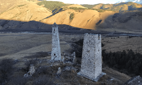 О происхождении названия "Хамхи".

Из научной публикациии Кодзоев Н. Д. " Топоним "Хамхи" и священое дерево".

Предания об основании Хамхи объясняют его название, как имя собственное основателя самого поселения, однако это не соответствует действительности. По ингушским традициям, при образовании топонимов для населенных пунктов, название которого происходит от имени собственного, добавляется компонент, указывающий на тип поселения, например, это могут быть слова «пхьа» (ГIолашпхье), «кхала» (Эги-Кхала), «коа» (Зовра-Коа) или «юрт» (Той-Юрт) и т.д. В случае же, если к названию не добавлен такой компонент, т. е. название населенного пункта состоит из одного слова (Таргим, Хамхи, Карт и т.д.), то такое название не происходит от имени собственного человека. В таком случае в названии заложен другой смысл. Обычно рассказы об основателях того или иного населенного пункта или общества возникают намного позднее его основания в попытках объяснить это название.

В.Б. Виноградов и К.З. Чокаев отмечали, что «термин “Хамхи” не поддается четкой этимологизации, особенно в своей первой части. Вторая часть слова более прозрачна в этимологическом отношении — хи — “вода, река”» .

Исследователь топонимии Чечни и Ингушетии А.С. Сулейманов приводит народную этимологию Хамхи: «оценить, почитать, уважать и т.д.». Данная этимология произведена от ингушского слова «хам». Возможно, что название поселения Хамхи связано с понятием «священного дерева»: от ингушского «хам» — «ценное, почитаемое, священное» и «хи» — «ствол, дерево». Действительно, культ «священного дерева» присутствует в мифах большинства народов мира с самых древних времен.

Слово «хи» («дерево») имеет соответствие и в грузинском языке — «хе». В своих лингвистических работах учёный Н.Я. Марр, известный своими исследованиями в области лингвистики, востоковедения, кавказоведения, истории, этнографии и археологии, высказал гипотезу, что грузинское слово "хати" и армянское "хач", имеющие общий корень, происходят от грузинских названий деревьев "хе" и "дзели". Далее, опираясь на исторические сведения исконного почитания деревьев в древней Грузии и древней Армении, Николай Яковлевич выдвигает положение о том, что термины «хе» и «дзели», а также соответствующая мегрельская форма названия дерева джа (за) первоначально означали культовое дерево, а в частности дуб и липа.

У горных грузин дерево изобилия называлось словом «хемхвивани», которое напоминает по своему звучанию ингушское «хамхи». На храме Тхаба-Ерды, расположенного вблизи Хамхи, находился фрагмент плиты из обожженной глины, на которой было изображено дерево, по сторонам которой находились две серны. Данный фрагмент плиты (кирпича типа черепицы) был найден в храме Тхаба-Ерды в 1901г. В 20-х годах ХХ в. этот фрагмент хранился в Ингушском краеведческом музее во Владикавказе. Дальнейшая его судьба неизвестна.

Образ «священного дерева» также был широко распространен в древних цивилизациях Передней Азии и Закавказья.

Этнограф, грузиновед В.В. Бардавелидзе сообщает о сванском рисунке с изображением сосны, «к ветвям которой тянутся стоящие по сторонам дерева две фигуры коз», что представляет, по ее мнению, «весьма близкие параллели широко распространенного в древневосточном искусстве мотива “мирового дерева” или “древа жизни”».

Изображения козлов по обеим сторонам «священного дерева»  — «древа жизни и изобилия» известны со времен Шумера. На печати должностного лица из храма Урука (Шумер, 4–3 тыс. до н.э.) изображен куст с цветами, символизирующего «священное дерево», с богиней Инанной и двумя козлами по обеим сторонам «дерева» .

Таким образом, вполне вероятно, что в названии башенного поселения Хамхи, зафиксирован культ «священного дерева».

Хамхи — одно из крупнейших башенных поселений Горной Ингушетии замкового типа, расположено в центре Таргимской котловины на левом берегу р. Ассы. В настоящее время Хамхи административно входит в состав Джейрахского района Республики Ингушетии.